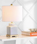 21.5 Inch White And Navy Ceramic Ginger Jar LED Table Lamp With Fishnet Chinoiserie Pattern on desk with books