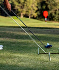 Golfer using All In One Golf Training Tool With 11 In 1 Alignment Sticks And Swing Plane System To Dial In Aim and Swing Path on grass