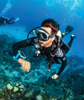 Diver underwater using Luna 2.0 AI Wrist Dive Computer With Bluetooth, Easy Read Wide LCD, visible on wrist, coral reef in background