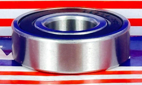Side view of S6204-2RS Hybrid Ceramic Bearing 20x47x14mm ABEC-5 with stainless steel rings and rubber seals displayed on table.